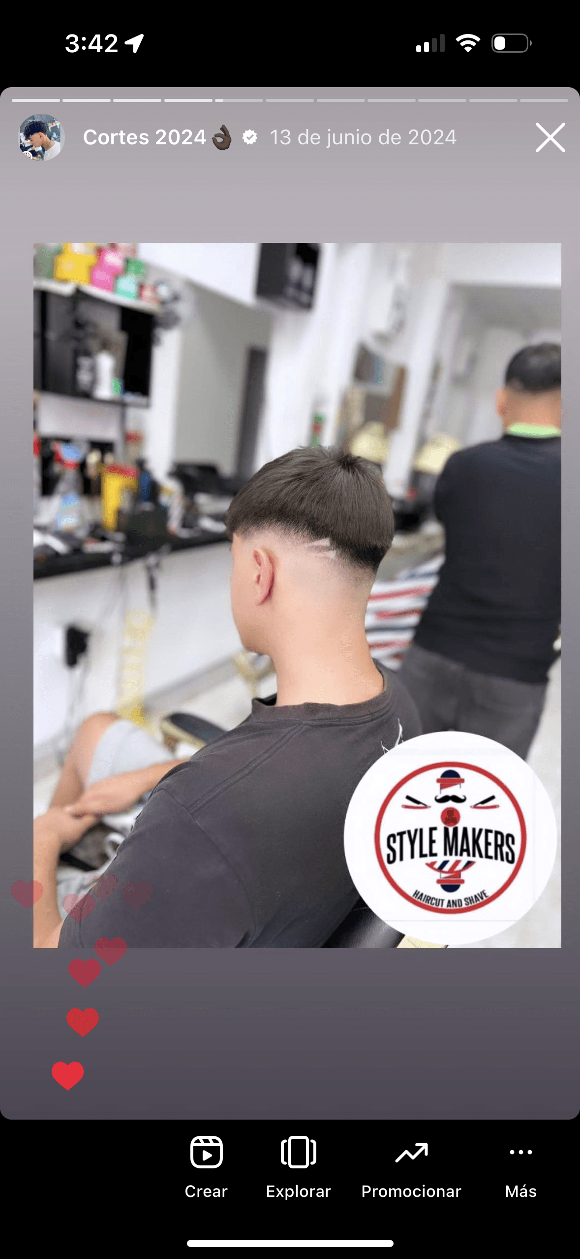Joven con un corte de pelo degradado y diseño de líneas en una barbería moderna.